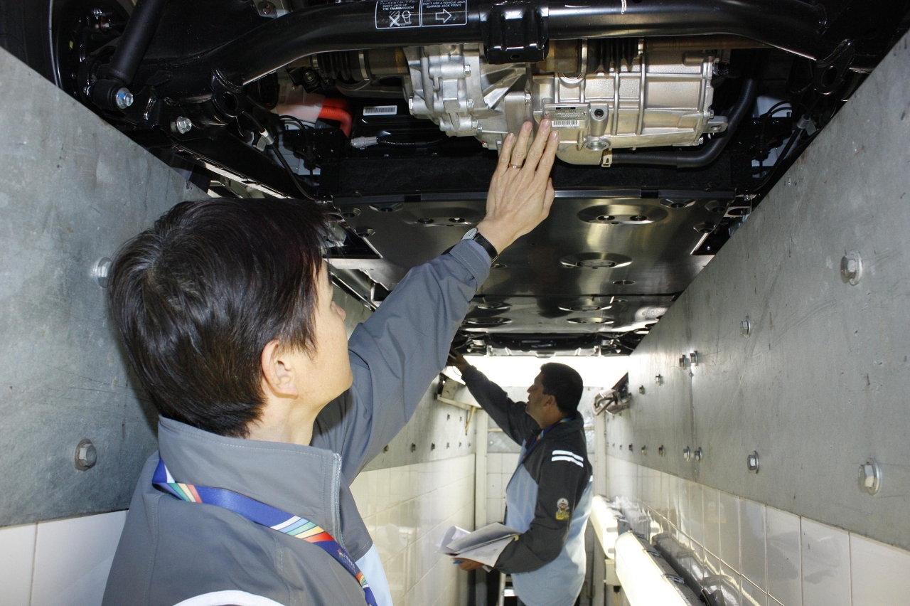 交通事務局技術人員仔細檢查電動汽車的底盤結構