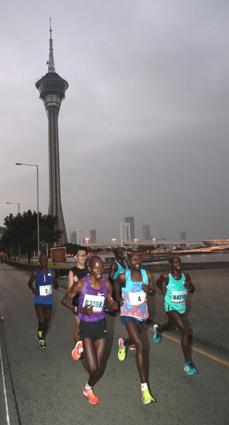 Felix Kiptoo Kirwa e outros atletas de frente passando a Torre de Macau