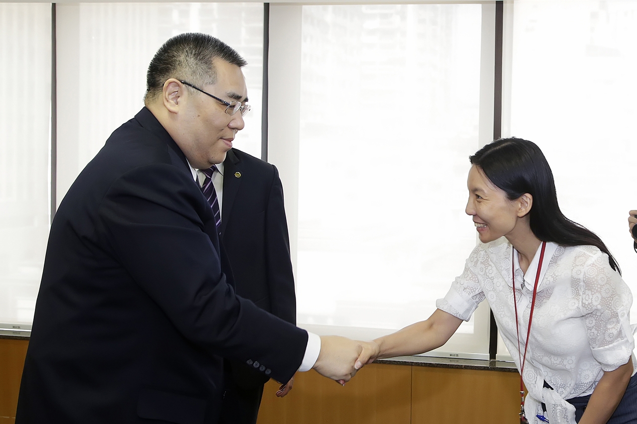 The Chief Executive, Mr Chui Sai On, shakes hands with a front-line staff member from one of the public departments related with either the economy or with finance.