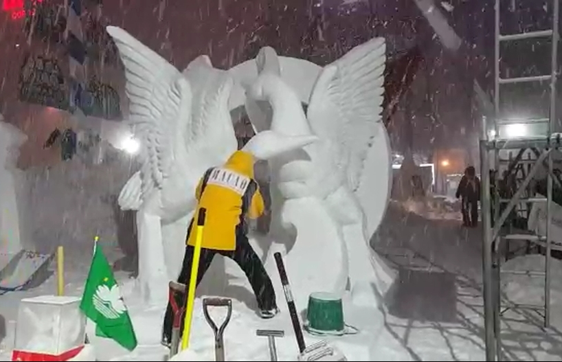 Membro da equipa de Macau a trabalhar na escultura Grou Dança em Recepção da Primavera em noite muito fria