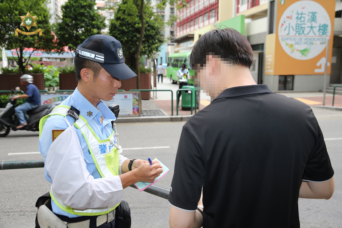 警員向違規過馬路的行人作出檢控