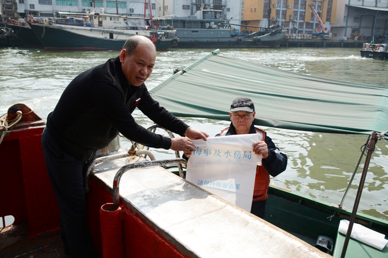 Trabalhador da DSAMA a distribuir sacos de lixo aos pescadores