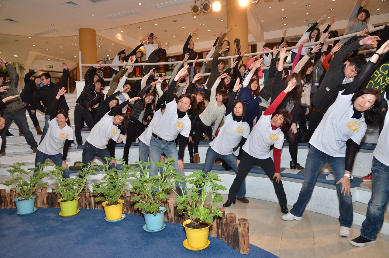 Event participants doing warm up exercise altogether for stretching and relaxing purposes.