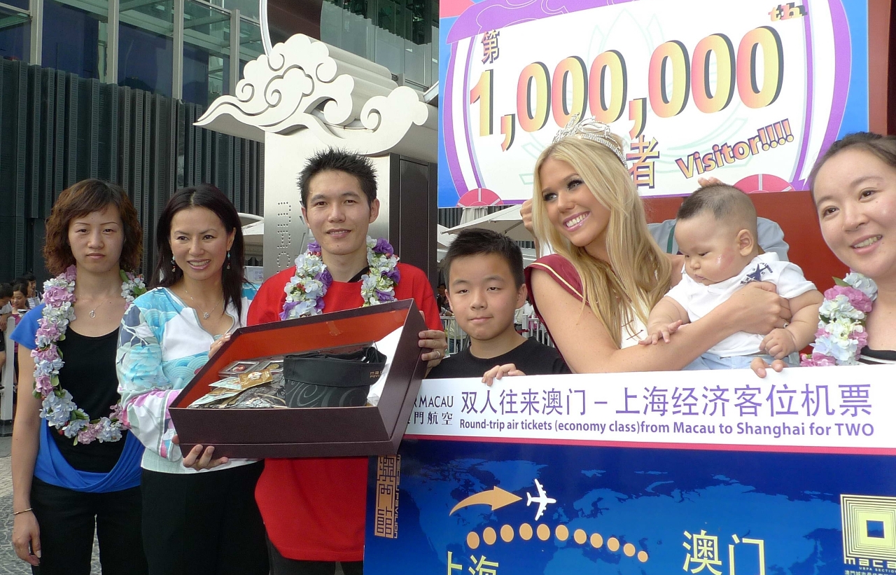 A coordenadora do Gabinete Preparatório para a Participação de Macau na Exposição Mundial de Xanghai, Christiana Ieong, oferece uma lembrança ao senhor Zhang (terceiro,à esquerda), o milionésimo visitante do pavilhão de Macau.