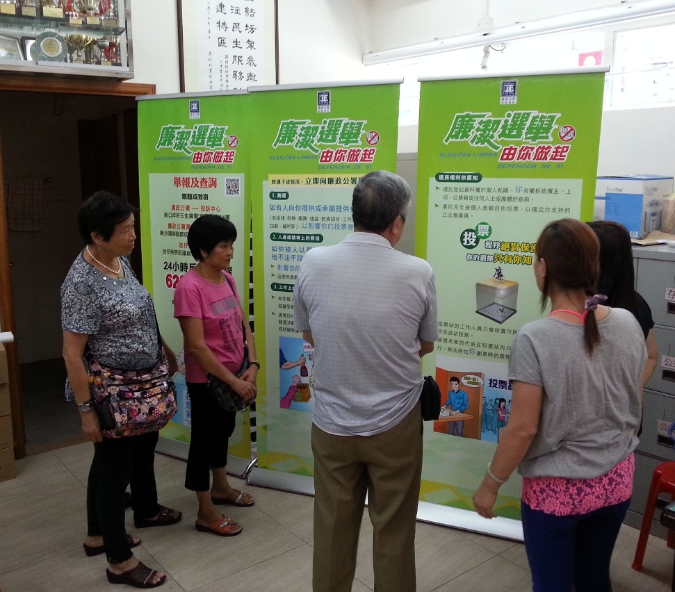 Cidadãos lendo o teor da exposição itinerante comunitária