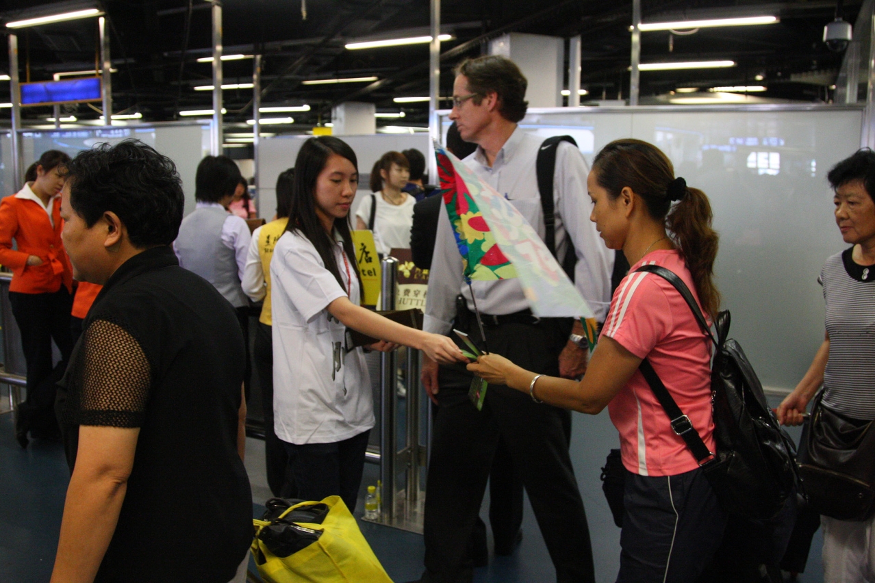 Staff distribute leaflets to travelers at ferry terminal